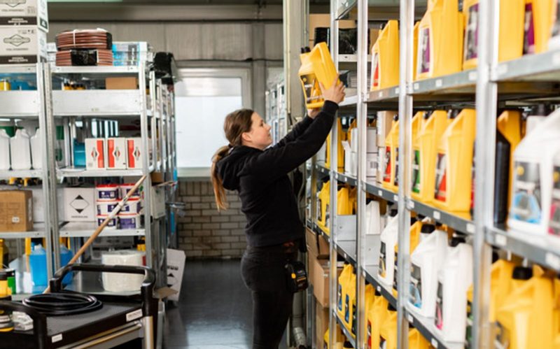 Collega zet jerrycans olie in de stelling